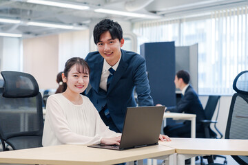 先輩社員から業務を教えてもらう新人の女性