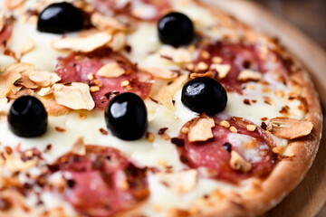 Pizza with salami and mozzarella cheese. Wooden background. Soft focus. Close up.