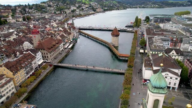Stunning aerial footage of Kapellbr&uuml;cke, the iconic Chapel Bridge, showcasing the picturesque beauty of Lucerne, Switzerland.
