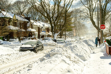snow covered street in residential neighborhood with cars in snow banks shot in Toronto Canada after a major winter storm