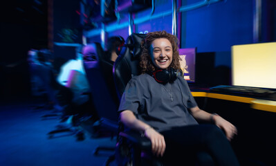 Young female gamer enjoying cyber game in esports arena with friends