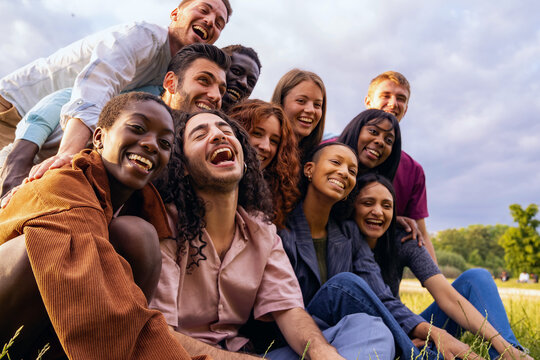 Diverse Happy Friends Laughing Outdoors in a Park, Multicultural Young Adults Enjoying Togetherness
