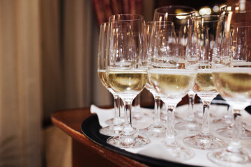 Tray with champagne glasses ready for celebration. Luxury banquet setting for birthdays, weddings, and special events. Sparkling wine served in a festive atmosphere. Cheers to joy and success!