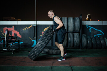 Man Lifting Tire During Nighttime Workout at Outdoor Gym