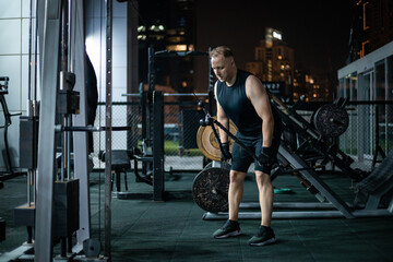 Man Working Out On A Cable Machine In A Gym At Night