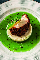 Chicken breast cooked sous vide in beetroot breading with couscous garnish and spinach sauce. Beautiful, restaurant-style presentation of the dish. Healthy food concept. Close-up