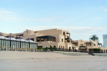 Modern beachfront resort architecture with ocean view and palm tree. Miramar Al Aqah Beach Resort, Fujairah UAE