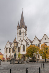 Obraz premium 30 october 2024, Sibiu, Romania. Morning view on the Sibiu Lutheran Cathedral, Catedrala Evanghelică Sfânta Maria. Cityscape during autumn. Historic building in the city center of Sibiu.