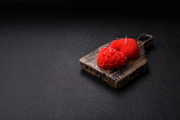 Red wax candle in the shape of a heart as decor for Valentine's Day