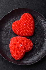 Red wax candle in the shape of a heart as decor for Valentine's Day