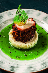 Chicken breast cooked sous vide in beetroot breading with couscous garnish and spinach sauce. Beautiful, restaurant-style presentation of the dish. Healthy food concept. Close-up
