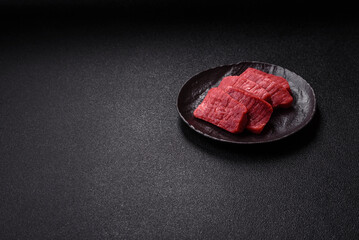 Raw beef tenderloin cut into slices with salt and spices