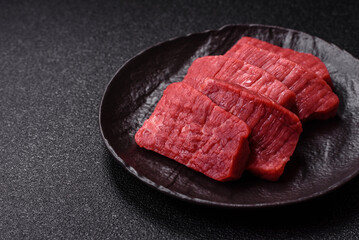 Raw beef tenderloin cut into slices with salt and spices