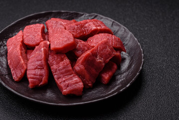 Raw beef tenderloin cut into slices with salt and spices