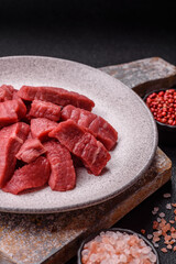 Raw beef tenderloin cut into slices with salt and spices