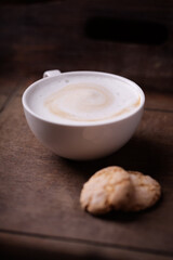 Cappuccino on dark wooden background. Soft focus. Close up.