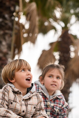 Fototapeta premium A brother and sister enjoying their time together outdoors, running, playing, and hugging each other. Their joyful expressions and playful energy capture the bond and happiness of sibling companionshi