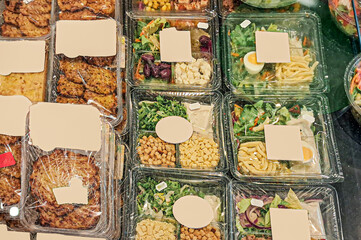 variety of prepackaged organic meals and salads displayed in the supermarket, packed in transparent...
