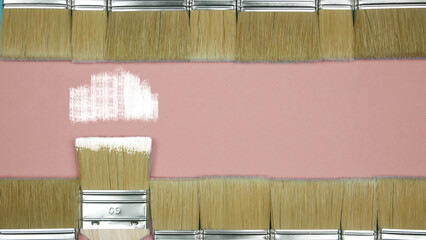 Brushes for painting walls horizontally in two rows with white paint on a beige background. Place for text