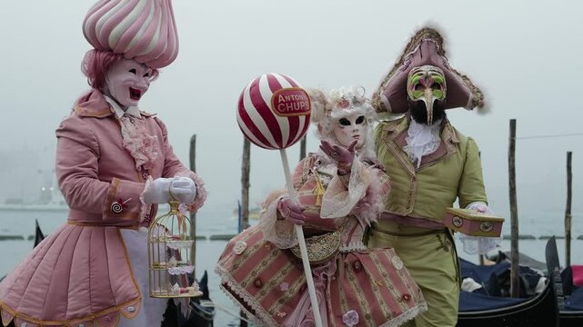 Venice, Italy - People dressed in carnival masks are photographed by tourists in the scenery of the ancient Venetian palaces
