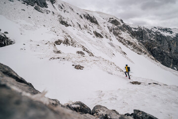 Alpine mountain athlete running and climbing in snow covered winter mountain alpine landscape. Extreme outdoor activities in Hochschwab mountain range, Austria.