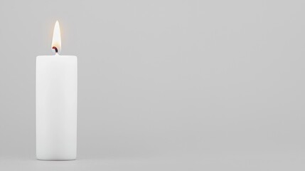 Single white candle flame on gray background.  Possible use stock photography