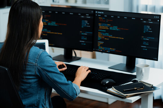 Young Asian in IT developer creating with typing online information on pc with coding program data of website application, wearing jeans shirt. surrounded by safety analysis two screens. Stratagem.