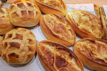 Freshly baked loaves of bread displayed on shelves in a bakery or cafe. Food or lunch concept.