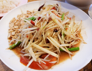 Close-up papaya salad (Som Tam) Popular traditional Thai food with spicy flavors on white plate, Top view of illustration, concept for restaurant menu.