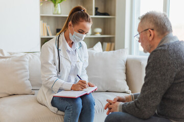 Female doctor examining older senior man in doctor office or at home. Old man patient and doctor...