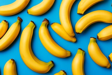 Yellow bananas arranged on blue background for fruit, food, healthy eating, or dietary supplement imagery