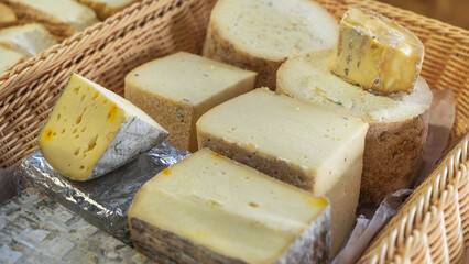 A vibrant display of craft cheeses at a farmer's market, showcasing a diverse selection of unique homemade varieties. Perfect for cheese lovers seeking fresh, artisanal flavors.