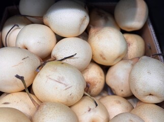 A bountiful collection of fresh, ripe white pear beautifully nestled in a charming basket, perfect for healthy eating. Close-up