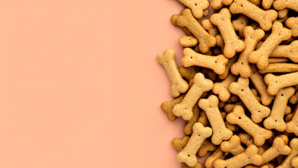 Fototapeta premium Close-up of bone shaped cookies for dogs and puppies on light background with blank space for text, pet treats made from natural ingredients