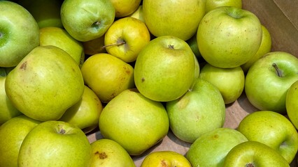A vibrant and colorful display of fresh, crisp green apples organized neatly in a bustling market settings. Close-up