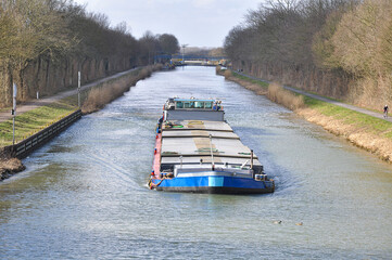 A barge sails through a calm canal in Germany. Loaded or empty, it is clearly on its way,...