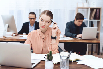 The girl is sitting at the computer.