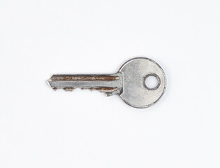 A worn silver key with scratches isolated on white