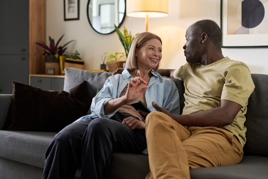 Smiling Couple Sitting on Couch in Living Room