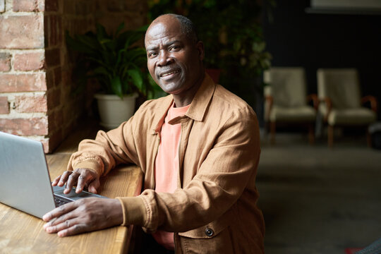 Smiling African American Man Working on Laptop Indoors