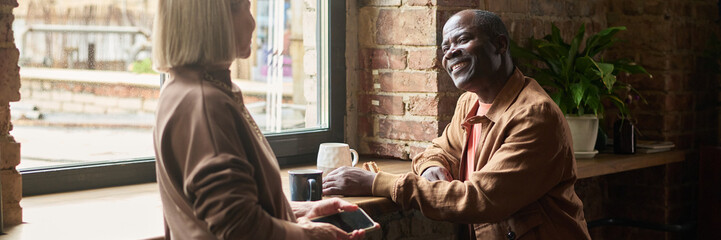 Two People Chatting and Smiling near a Window