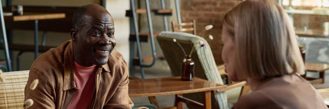 Smiling Man Engaging in Conversation in Vintage Cafe