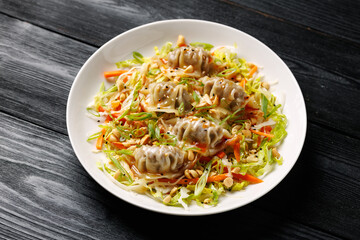 Gyoza Salad or Dumpling Salad with fresh vegetables, nuts and herbs. Asian food