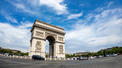 Fototapeta premium Famous Arc de Triomphe against nice blue sky Arc de Triomphe monument at Champs-elysees road in Paris, France