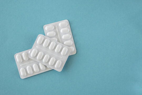 Tabletten or pillen in white package on the blue background.