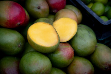 Fresh mangoes displayed showing ripe yellow interior at market stall