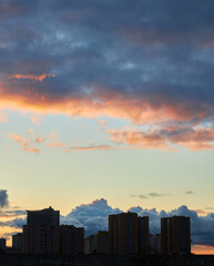 Sunset Behind Clouds with City Silhouettes