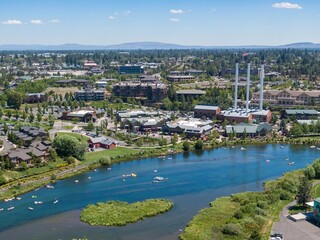 Aerial view of Old Mill District with people enjoying the Deschutes River. Picnicking, floating, and relaxing. Sunny day. Deschutes River, Bend, Oregon, USA