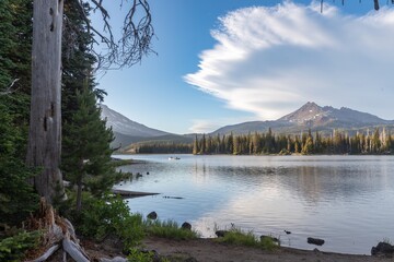 Peaceful scene of a canoe on a serene Sparks Lake, nestled amongst towering pines and a majestic...
