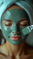 Woman applying green clay mask on her face while relaxing at home during a self care session, enjoying the soothing sensation along with peace and tranquility